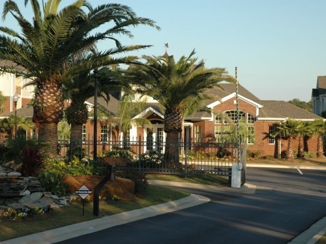 The gated entrance at Cypress Cove Apartments, Mobile, framed by date palms GCL installed