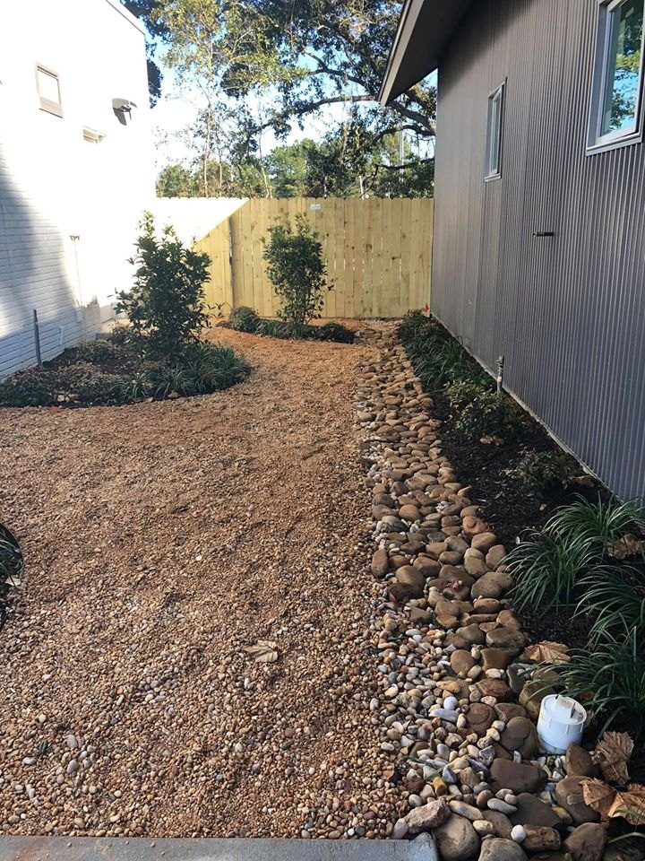 A finished bed renovation with river rock borders and fresh plantings