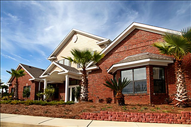 Brick clubhouse with palm and shrub planting at The Retreat at Schillinger, Mobile